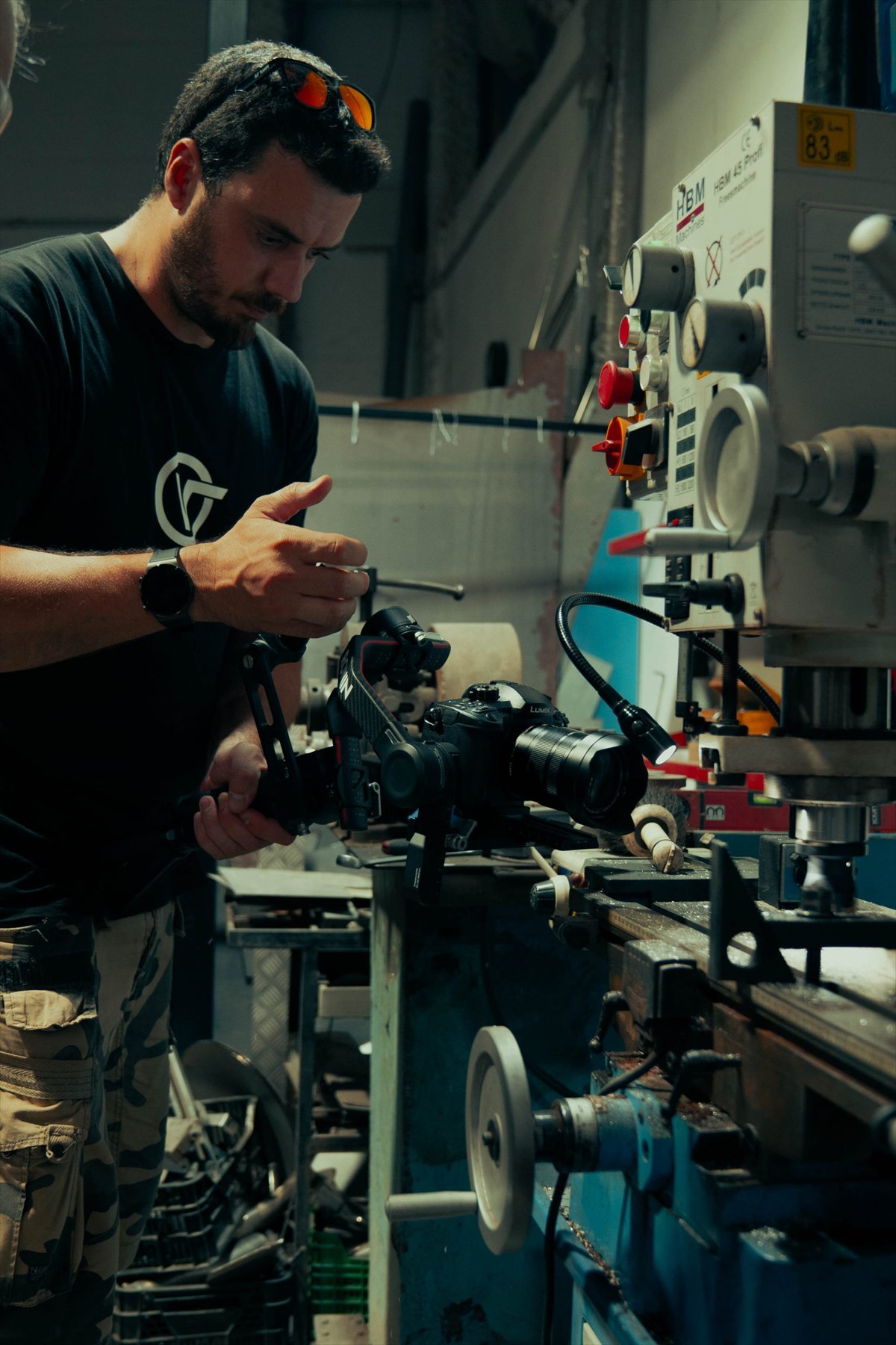 Cédric Sierras grabando con una cámara en un taller industrial.